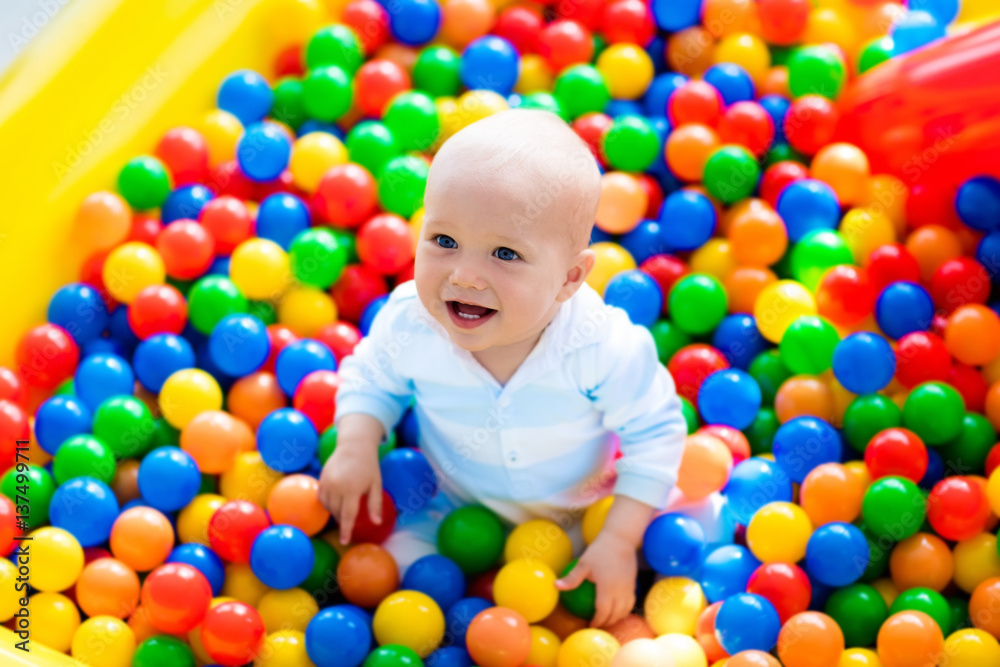 Child playing in ball pit on indoor playground Child playing in ball pit on indoor playground