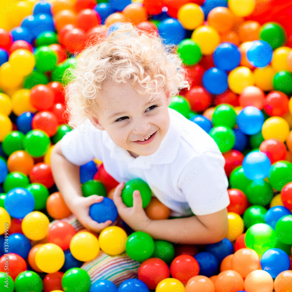 Fototapeta premium Child playing in ball pit on indoor playground