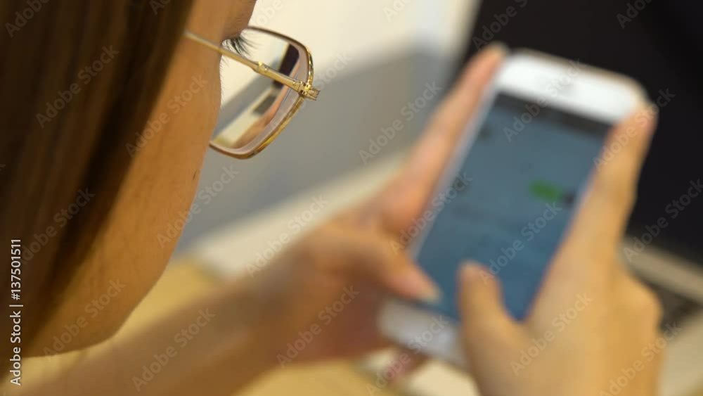 4K Asian Woman Using Smartphone with blur on the digital mobile touch screen to chat and contact people. Good time to surfing the internet, check social network and write text done on phone device-Dan