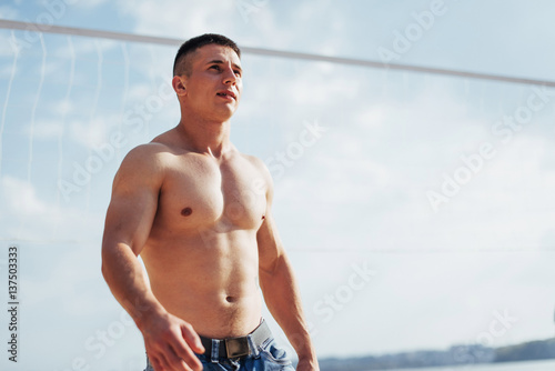 Beautiful athletic bodybuilder guy, carries out exercises with d