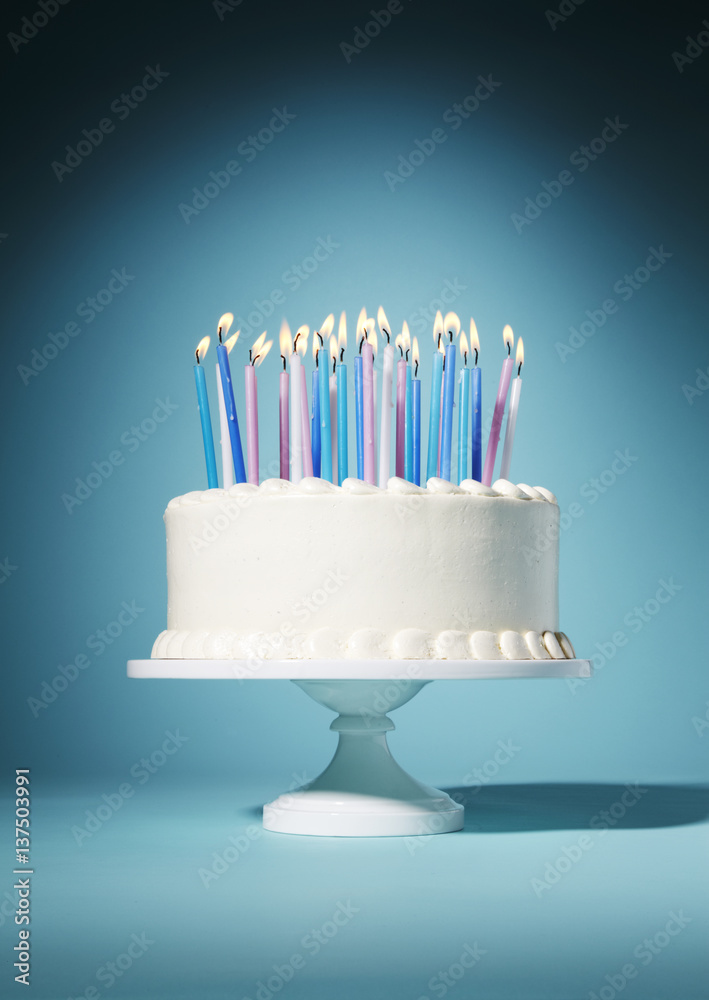 White birthday cake with lit candles Stock Photo | Adobe Stock