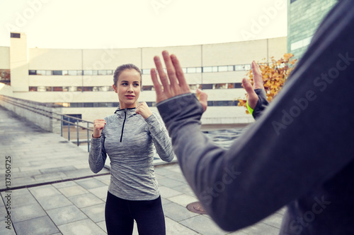 woman with trainer working out self defense strike photo