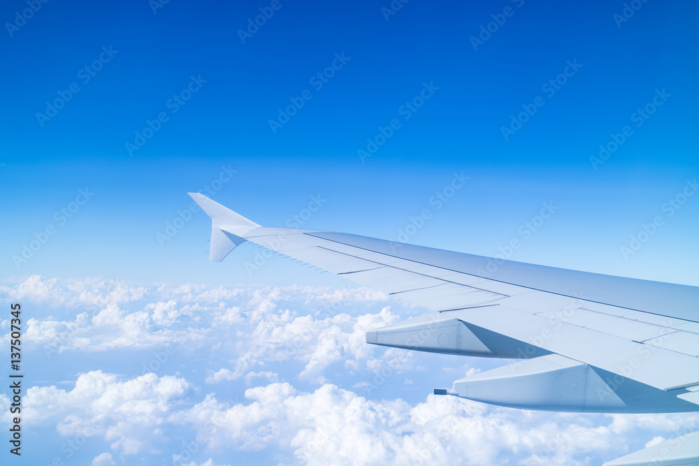 Obraz premium Airplane wing above cloud seen through window