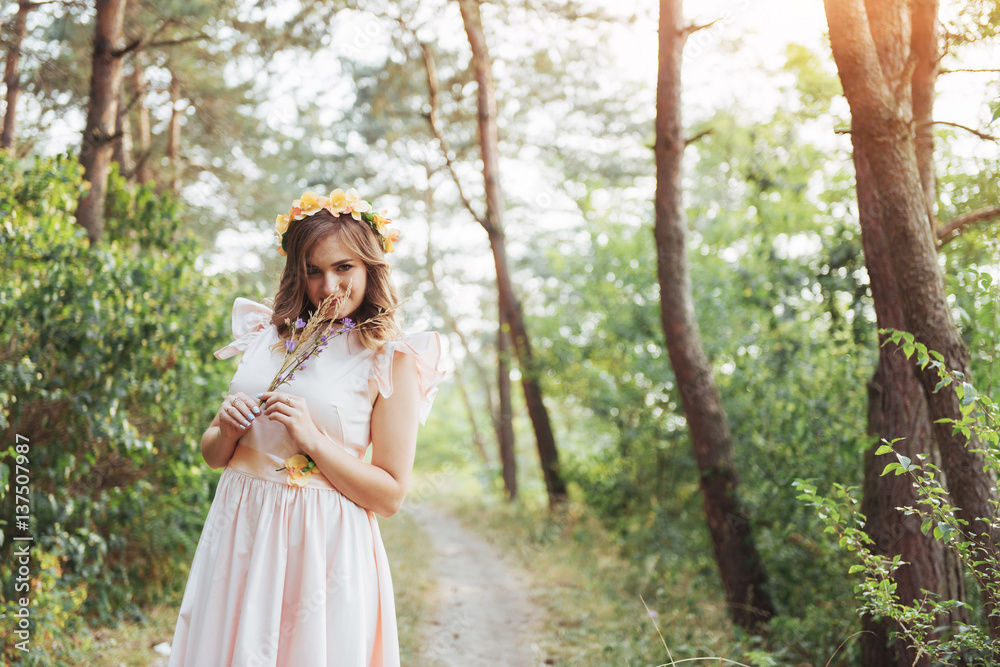 Naklejka premium Happy young woman in long dress a beautiful pine forest