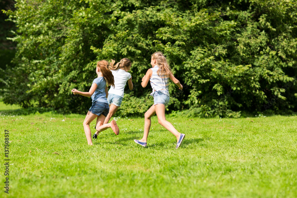 group of happy kids or friends playing outdoors