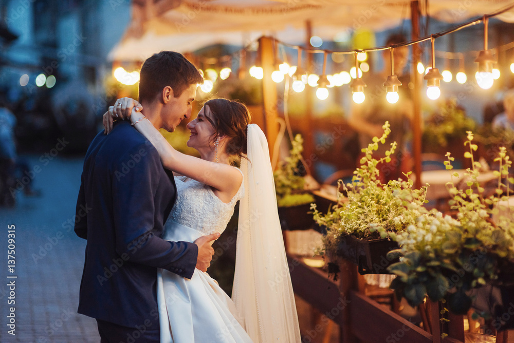 Naklejka premium wedding couple at night lighting. Cafe along with decoration lig