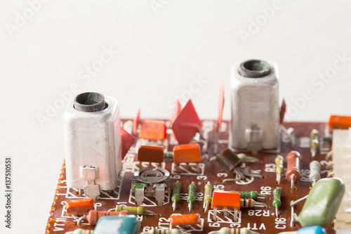 Old resistors capacitors close-up, selective focus. Vintage design circuit board and colorful electronic components. Shallow depth of field