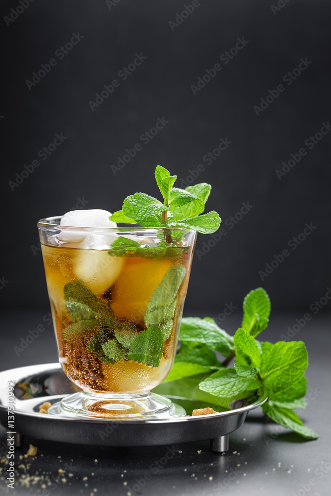 Mint Julep cocktail with bourbon, ice and mint in glass on black background Mint Julep cocktail with bourbon, ice and mint in glass on black background
