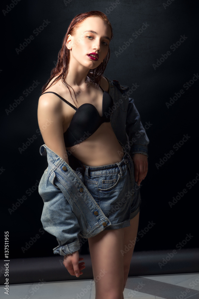 Beautiful woman with long red color straight hair and style makeup. Model posing on dark background.