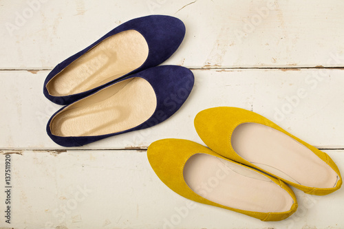 Blue and yellow women's shoes (ballerinas) on wooden background.