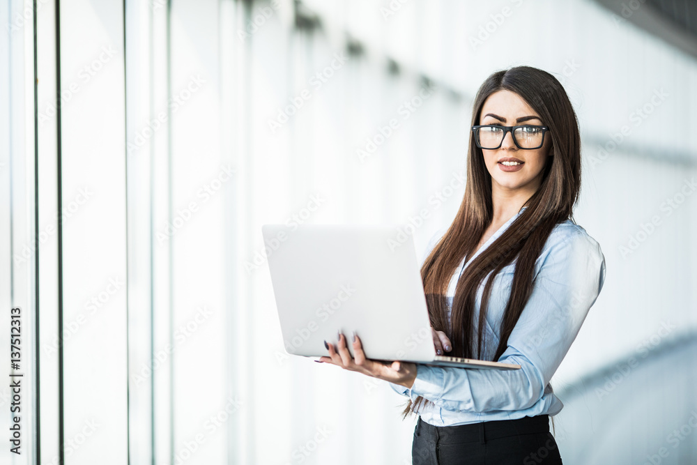 Business woman with laptop in modern office. Business woman with laptop in modern office.