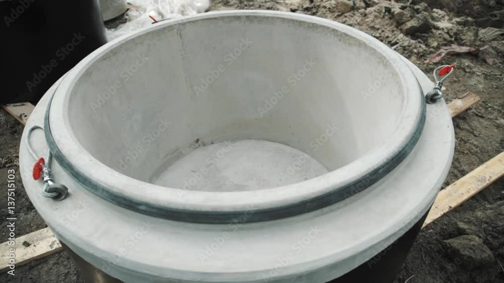 Upward tracking shot concrete chamber manhole ring laying on planks at building site Upward tracking shot concrete chamber manhole ring laying on planks at building site