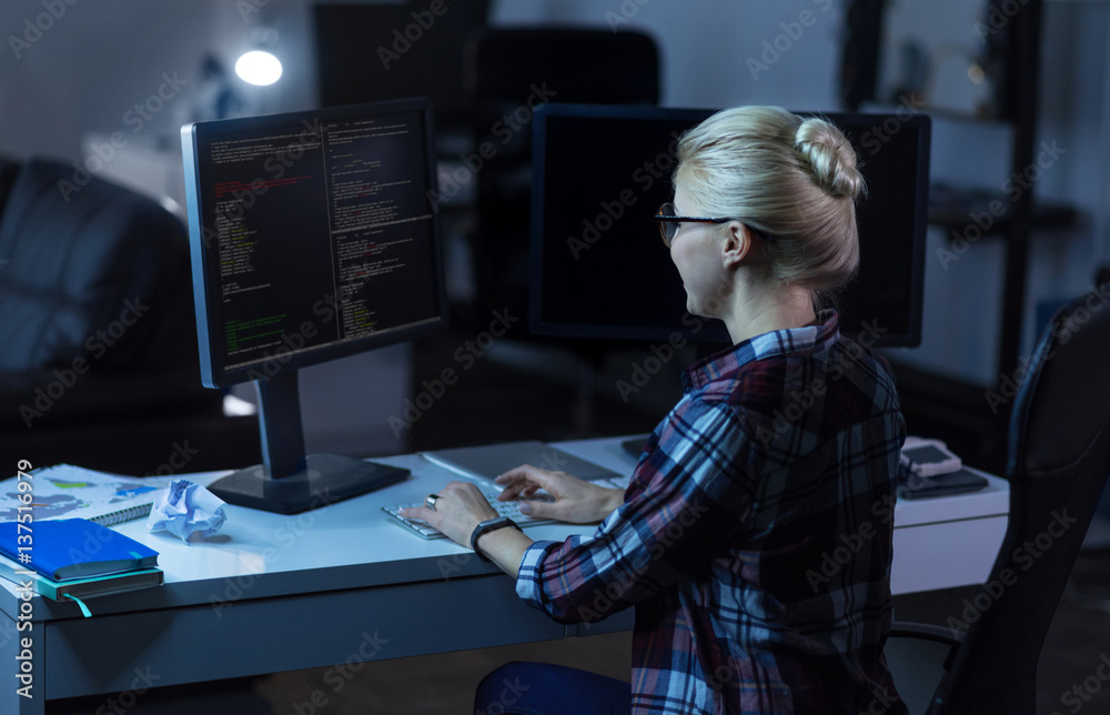 Cheerful IT girl working in the dark lighted room Cheerful IT girl working in the dark lighted room