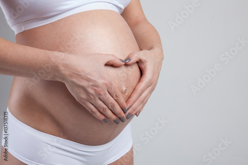 Wallpaper Mural Belly of a pregnant woman isolated on white background Torontodigital.ca