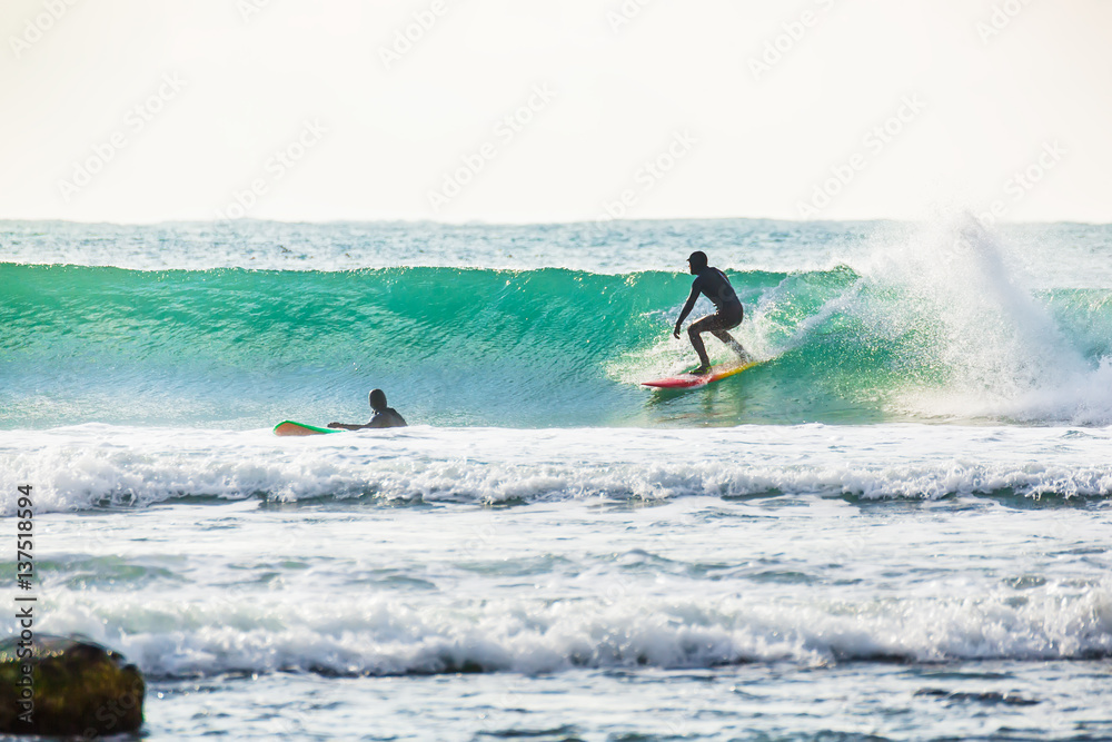 Surfing and beautiful blue wave in ocean. Surfer in wetsuit Surfing and beautiful blue wave in ocean. Surfer in wetsuit