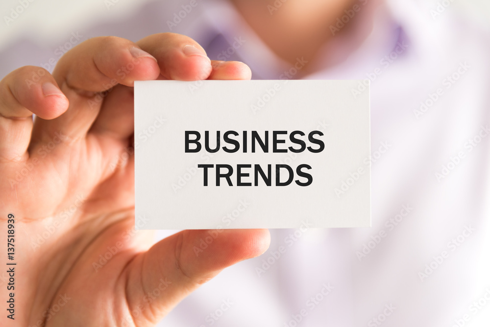 Businessman holding a card, text BUSINESS TRENDS Businessman holding a card, text BUSINESS TRENDS