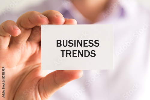 Businessman holding a card, text BUSINESS TRENDS