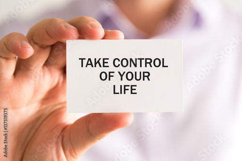 Businessman holding TAKE CONTROL OF YOUR LIFE card