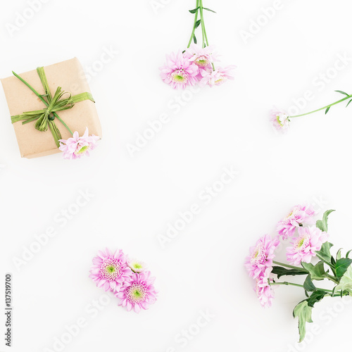 Fototapeta Naklejka Na Ścianę i Meble -  Paper gift box and pink flower on white background. Flat lay, top view. Floral frame.