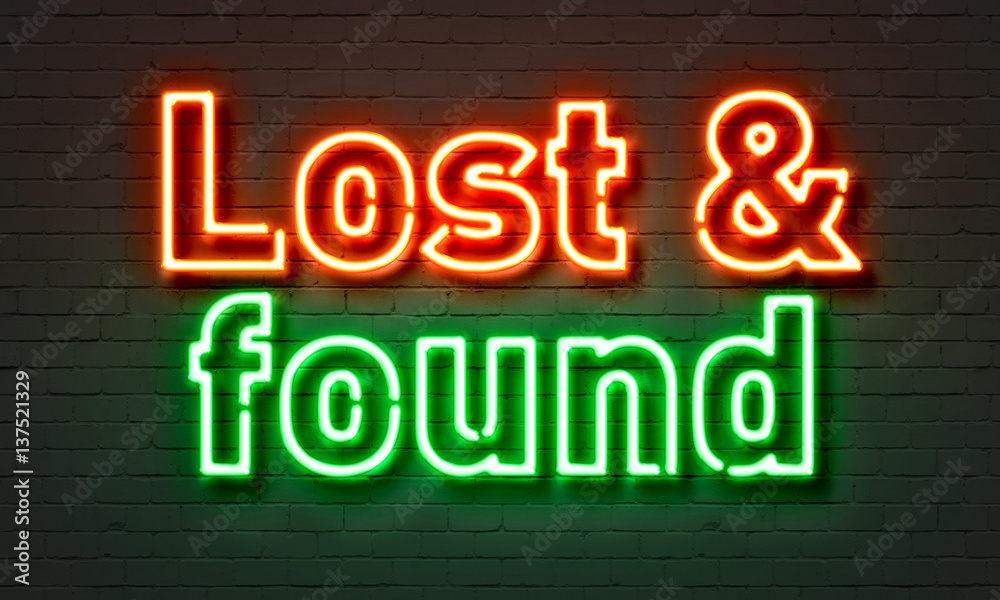 Lost & found neon sign on brick wall background.
