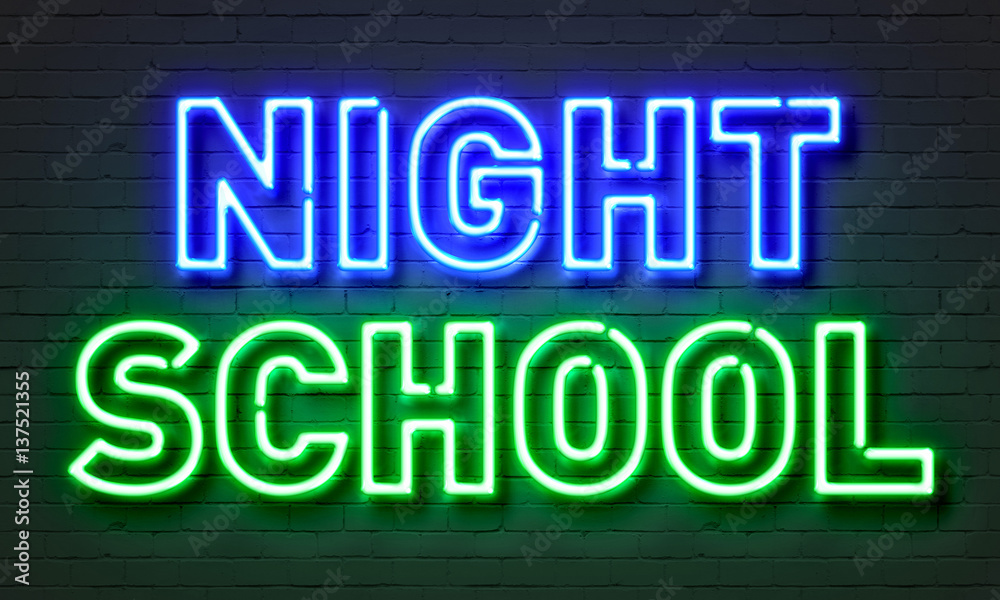 Night school neon sign on brick wall background.