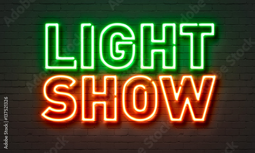 Light show neon sign on brick wall background.
