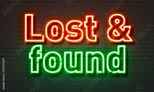 Lost & found neon sign on brick wall background.