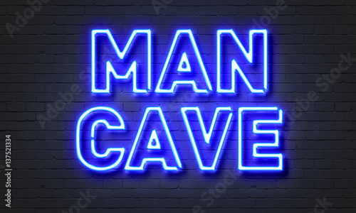 Man cave neon sign on brick wall background.