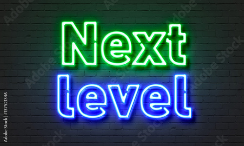 Next level neon sign on brick wall background.