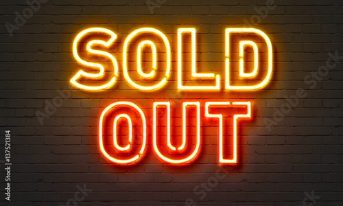 Sold out neon sign on brick wall background.