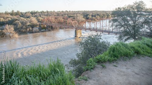 View of the red bridge, Fair Oaks, from the bluffs, with American River in flood