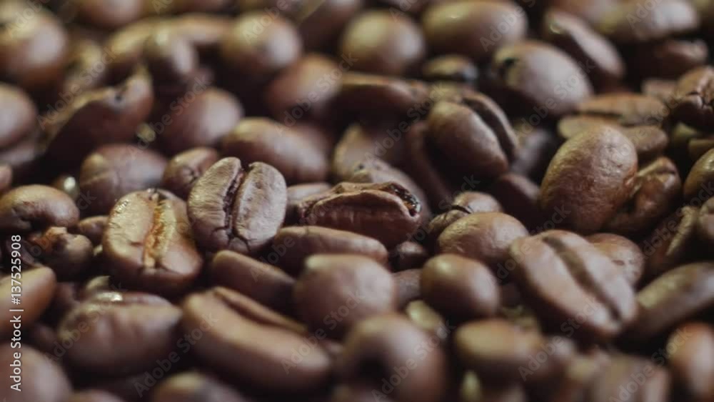 Roasted coffee beans on a table. Rotating. Close up, slow motion. Roasted coffee beans on a table. Rotating. Close up, slow motion.