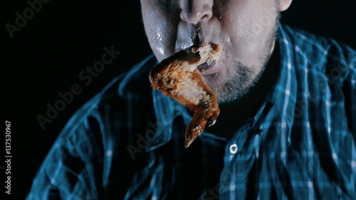 brutal man eating meat with blood slow-motion. concept of gluttony photo