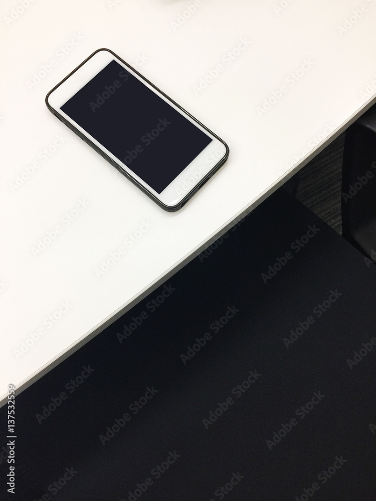 White smartphone in black case on white table White smartphone in black case on white table