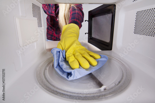 Hand with rag closeup inside the microwave