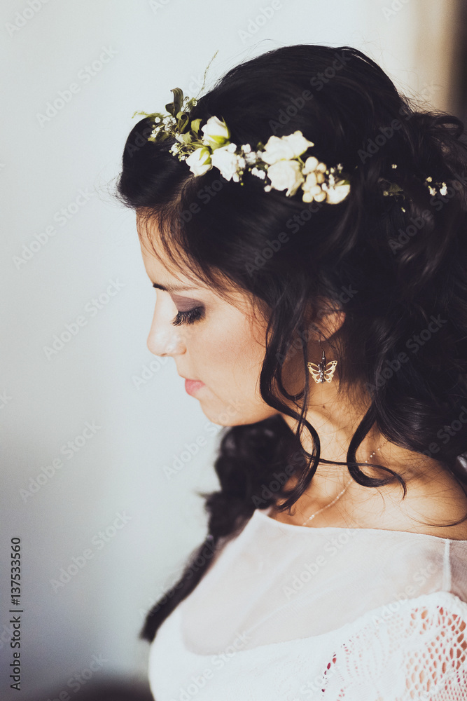 Potrtait od young bride with black hair in rustic style. Beautiful dress and hairstyle