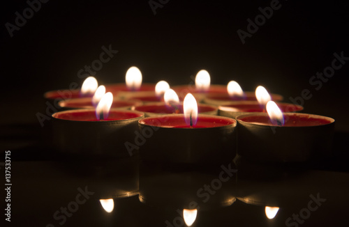 Burning candle isolated on black background.