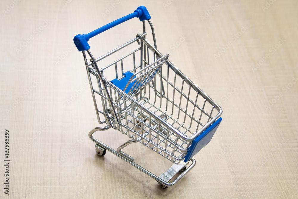 Mini shopping cart / supermarket trolley on a light background