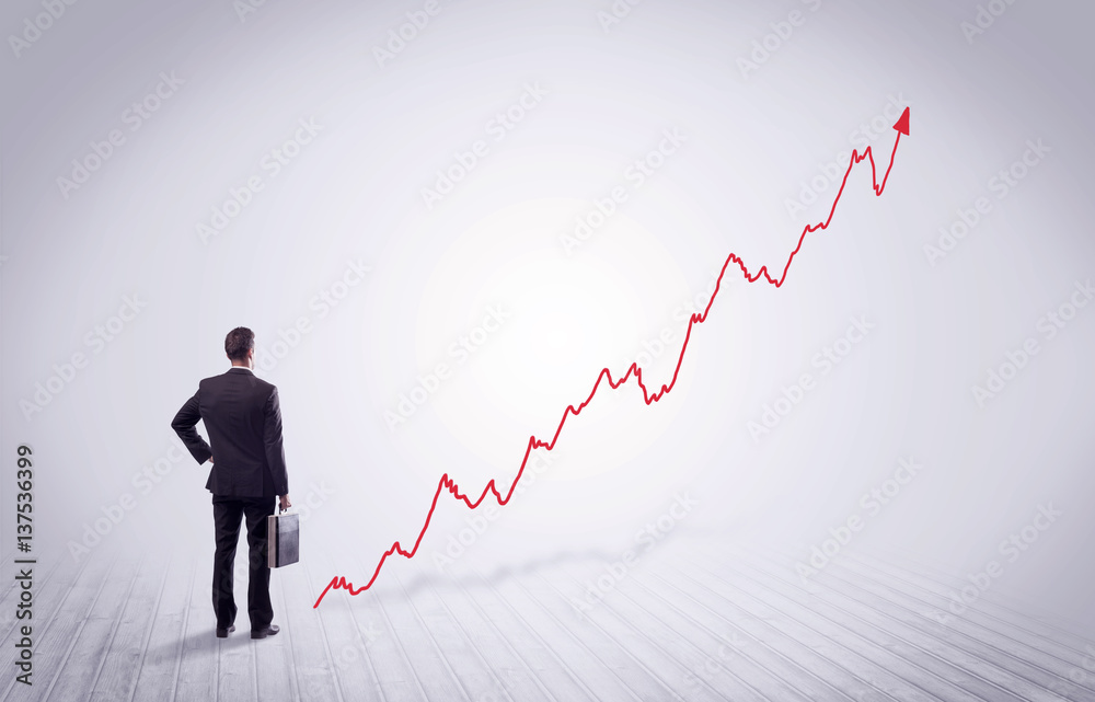 Standing businessman with red graph arrow