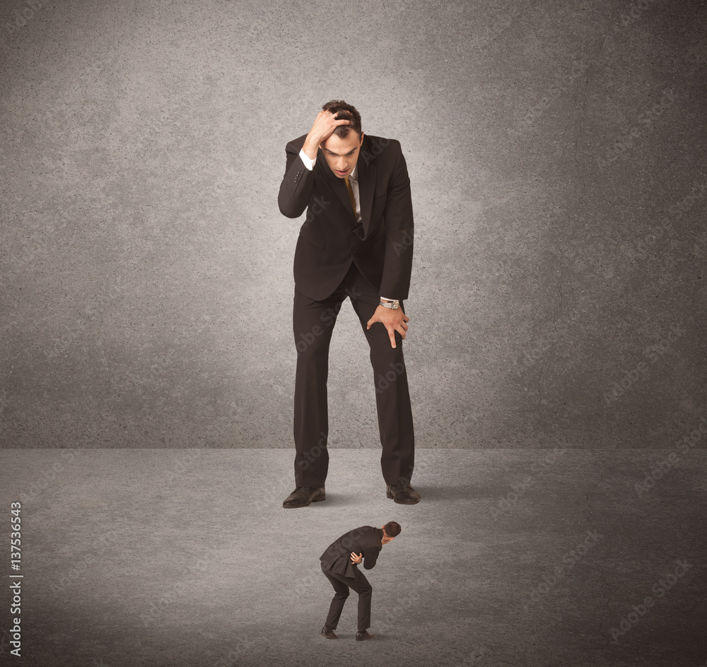 Obraz premium Big business man looking at small worker