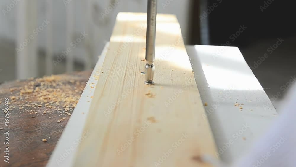 Hands of man using electric driller to spin the screw to the wood Hands of man using electric driller to spin the screw to the wood