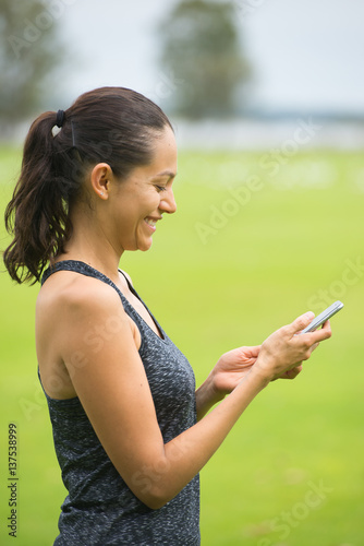 Young happy hispanic woman on smart phone