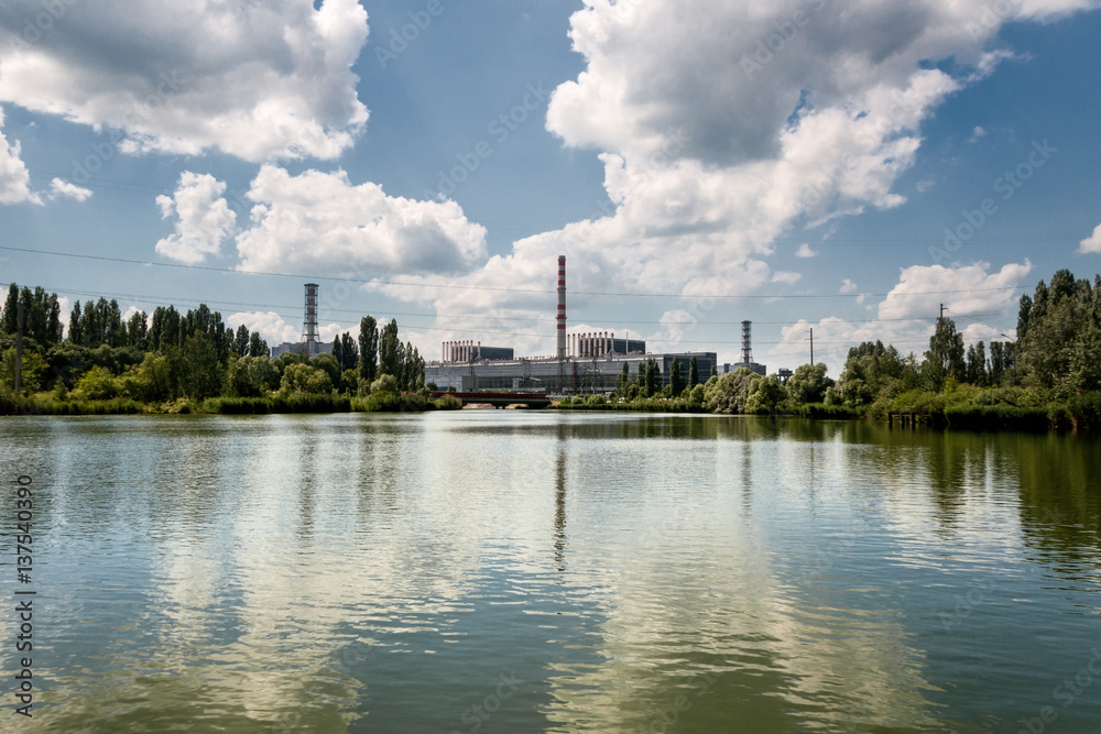 Naklejka premium Kursk Nuclear Power Plant reflected in a calm water surface.