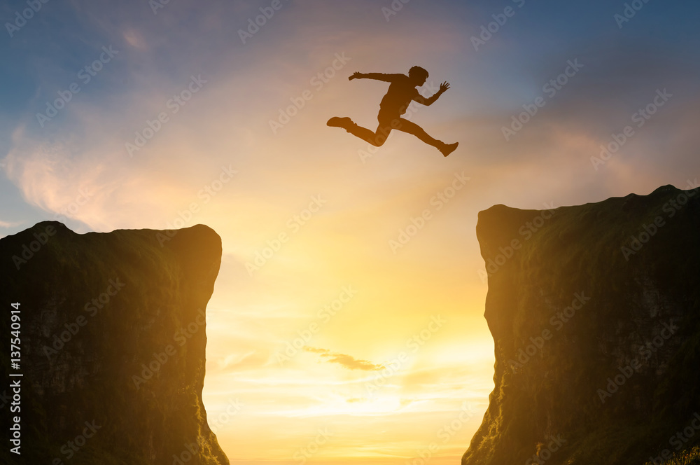 man jumping over the cliff, silhouette