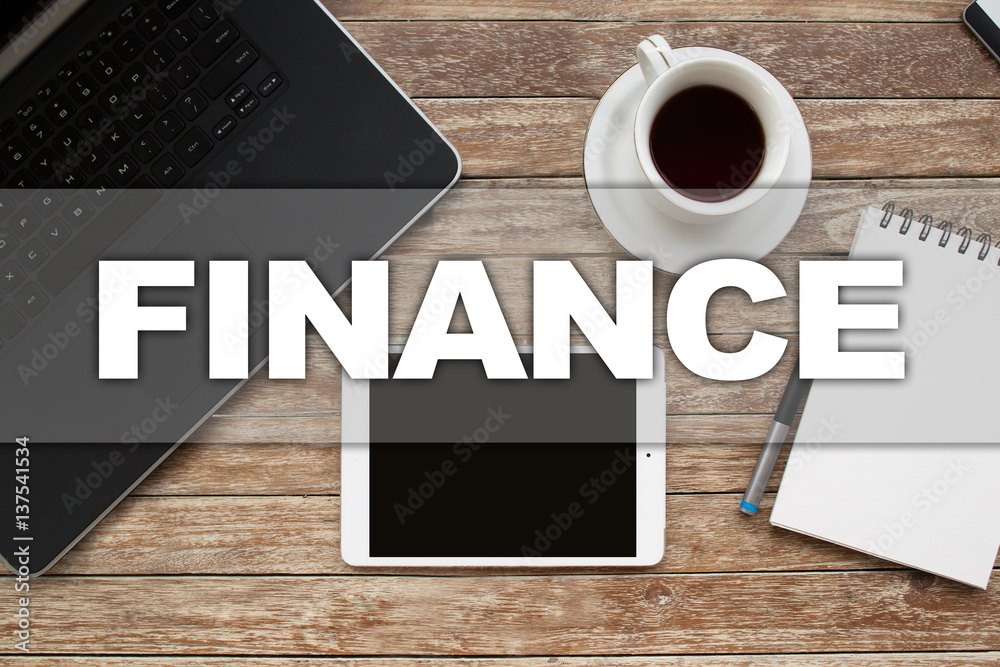 Tablet on desktop with finance text. Tablet on desktop with finance text.
