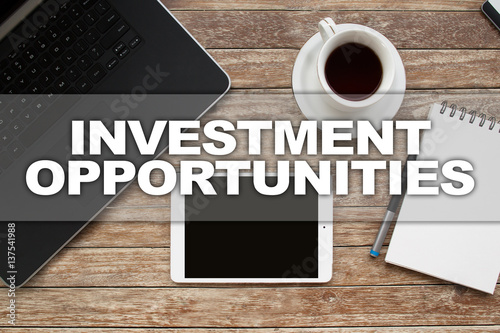 Tablet on desktop with investment opportunities text.