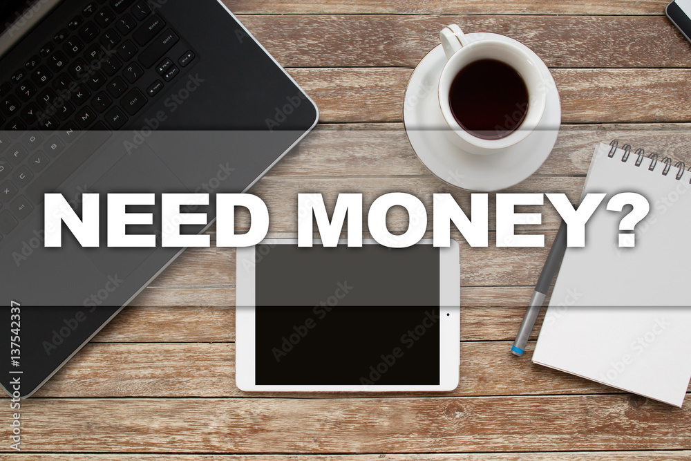 Tablet on desktop with need money text. Tablet on desktop with need money text.