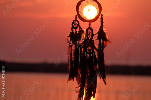 Silhouette of dream catcher with beautiful twilight background. boho chic, ethnic amulet.