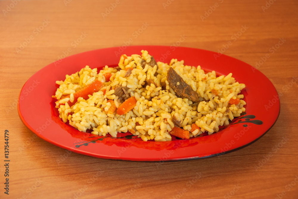 Uzbek pilaf of rice and meat on a ceramic plate Uzbek pilaf of rice and meat on a ceramic plate