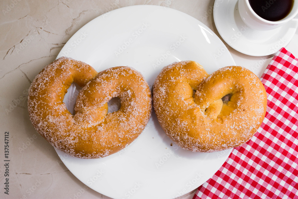 Pretzel in sugar on a marble table. Tasty dessert. Pretzel in sugar on a marble table. Tasty dessert.